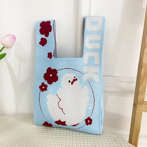 Detail of light blue knit tote bag with a cartoon duck pattern and white DUCK text