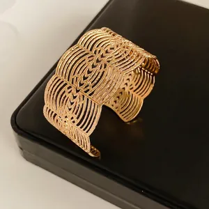 Golden lace cutout open bangle bracelet with elegant layered wave patterns for women