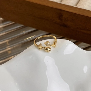 Macro view of gold tulip ring with sparkling micro-pave diamonds on a white tray