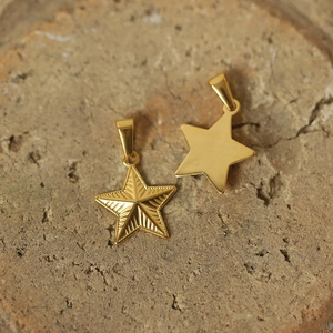 Detail of vintage gold plated sun god and unicorn star pendants on stone base