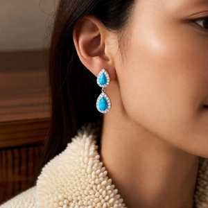 Detailed view of vintage silver drop earrings with blue turquoise and white zircons