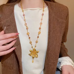 Collier vintage à pendentif fleur dorée et perles colorées sur un mannequin