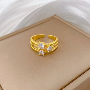 Three-layer gold open ring with sparkling pavé crystals on a jewelry storage box