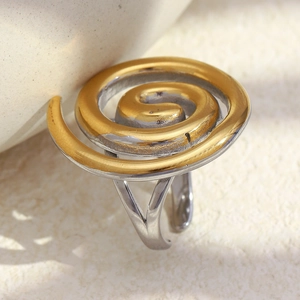 Macro shot of two-tone spiral open ring with gold and silver polished metal textures