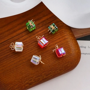 Close-up of handmade wire-wrapped crystal gift box pendants in red and green colors