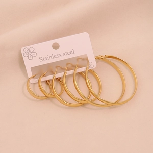 Three pairs of polished golden stainless steel hoop earrings in varying sizes on display