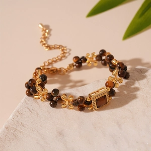 Detail of beaded necklace with tiger eye beads and a zircon-encrusted square pendant