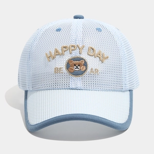 Close-up of breathable mesh fabric and brown bear embroidery on a blue kids baseball cap