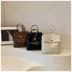 Detail of square-patterned stitched tote bags with metal twist-locks and dual handles