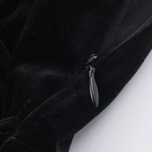 Gros plan détaillé de la fermeture éclair invisible sur cette robe courte en velours noir