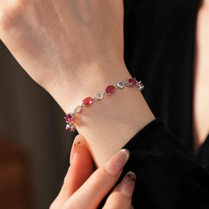 Detail of silver bracelet with oval pink zircons on wrist, elegant jewelry for women