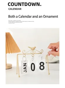 Detail of creative golden bird flip calendar on desk with cozy lamp and coffee setup