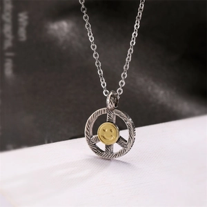 Macro view of vintage silver peace sign pendant with golden heart-eye smiley face detail