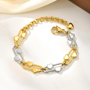 Detailed macro view of dual-tone link chain bracelet with heart charms and lobster clasp