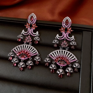 Detailed macro view of ethnic tassel earrings with red rhinestones and silver pins