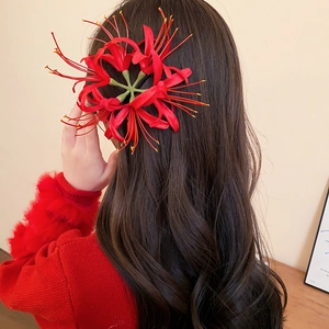 Detail showing red Lycoris Radiata hair clip on dark hair for festive styling