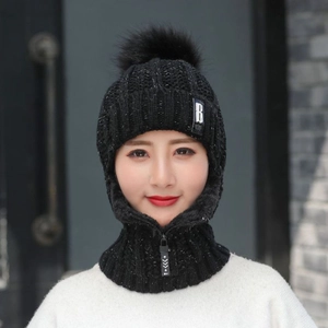 Détail du bonnet en tricot noir avec pompon et écharpe intégrée à fermeture éclair