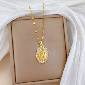 Macro detail of oval pendant with white crystals and gold portrait relief on silk