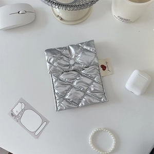 Close-up of metallic silver quilted storage bag with secure snap button closure