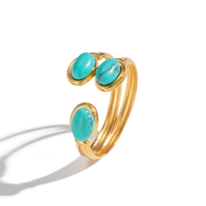Gros plan sur une bague ajustable dorée ornée de trois pierres turquoise ovales sur fond blanc