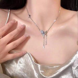Dettaglio ravvicinato di una collana argentata con fiocco in zircone e ciondolo a stella