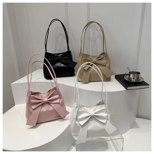 Detailed display of tote bags with oversized bows in pink, black, beige, and white colors