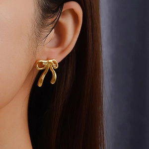 Elegant 18K gold plated stainless steel bow earrings with zircon stones on female model