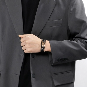 Detail of multi-layer leather bracelet for men featuring a gold infinity symbol charm