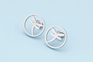 Macro detail of silver dragonfly silhouette earrings with crystal stud in circular frame