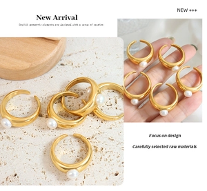 Detail of minimalist gold wide band ring with round white freshwater pearl inlay