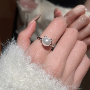 Detail of silver pearl ring with zircon cat ears on hand with soft white background
