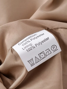 Étiquette d'entretien détaillée sur trench-coat marron montrant 100 % polyester