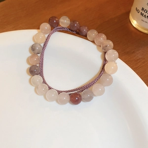 Détail d'un bracelet de perles roses et bleues avec cordon sur une assiette