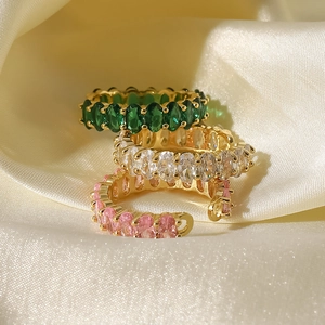 Detailed view of adjustable gold rings with oval emerald, white and pink zircon stones