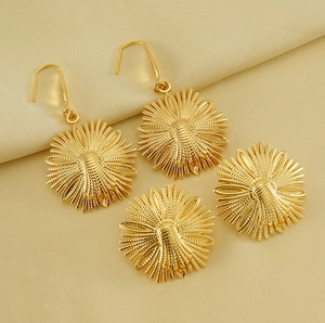 Detailed macro view of golden sunflower earrings with radial texture on silk background