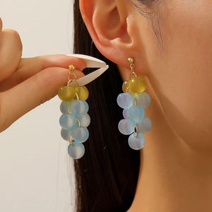 Close-up of beaded grape drop earrings featuring light blue and yellow-green beads