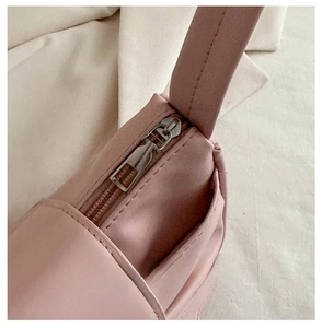 Close-up of the smooth metal zipper and pink leather texture on this bow shoulder bag
