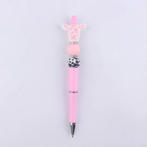 Detail of pink cow-themed DIY beaded pen with silicone charms and rhinestone spacers