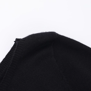 Primer plano detallado de las costuras y textura de punto del vestido negro línea A
