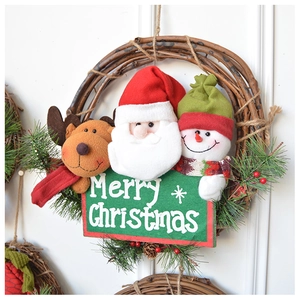 Detail of a Merry Christmas wreath with plush Santa, reindeer, and pine needles on a rattan ring