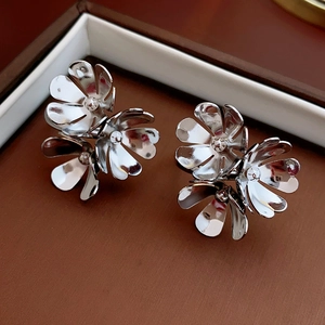 Detailed view of silver flower cluster earrings presented in a luxury brown jewelry box