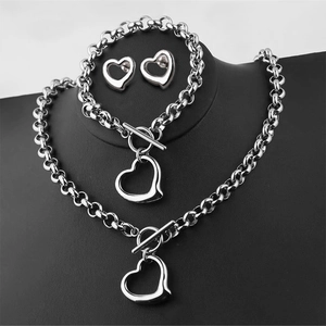 Detailed view of silver heart jewelry set with necklace and bracelet on a black display