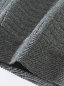 Macro detail of dark grey sweatshirt featuring waffle knit texture and ribbed cuff design