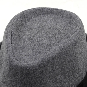 Close-up of the smooth wool felt texture and rounded crown of the dark grey fedora hat