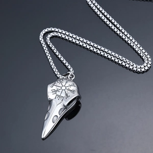 Macro shot of stainless steel crow skull pendant with engraved Viking compass on a chain