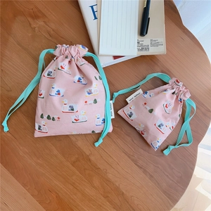 Detailed top view of pink cotton drawstring pouches with cute duck and swan patterns