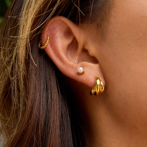 Elegant gold stainless steel jewelry set featuring hoop earrings, ear cuff, and pearl studs