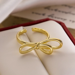 Minimalist 18K gold plated hollow bow open ring displayed on a premium leather jewelry box