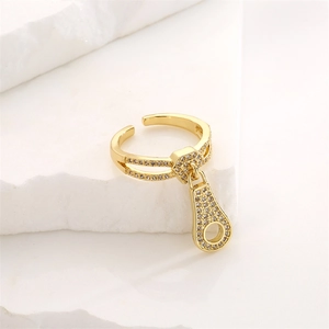 Detail of adjustable gold ring featuring a sparkling zircon zipper charm on white stones