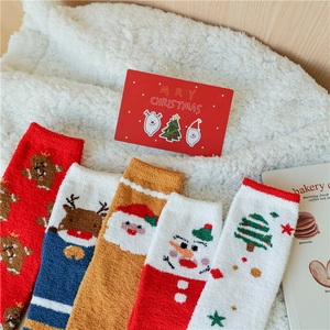 Gros plan de chaussettes de Noël douces en polaire avec motifs de renne et père Noël